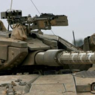 Un soldado israelí observa con unos prismáticos desde un tanque en la frontera israelí con la Franja