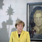 La canciller alemana, Angela Merkel, ante un retrato del excanciller Gerhard Schroeder durante una recepción, hoy, en Berlín.