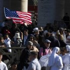 Una persona agita una bandera de Estados Unidos en la Plaza de San Pedro.