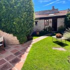El exterior de la vivienda en Adrados (Segovia) combina jardín, terraza y zonas de descanso al aire libre
