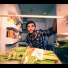 Un hombre mira el interior de un frigorífico
