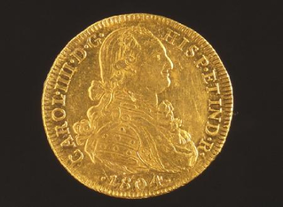 Moneda de ocho escudos acuñada por Carlos IV. Obra entregada al Museo Arqueológico Nacional en calidad de depósito por la Comisaría General del Patrimonio Artístico Nacional, el 12 de mayo de 1943.