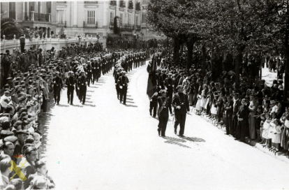 Desfile de fuerzas de la Guardia Civil en la plaza de Aragón a la altura del Gobierno Civil (a la izquierda) de Zaragoza, entre las calles Juan Bruil y Puigcerdá. En el reverso tarjeta postal con sello del productor.