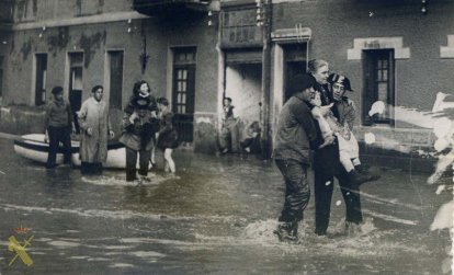 En la imagen se observa la ayuda humanitaria prestada por Mariano Manso Ruiz y otro guardia civil durante las inundaciones del mes de noviembre de 1933 en el barrio de las Arenas del término municipal de Guecho /Getxo en la provincia de Vizcaya.