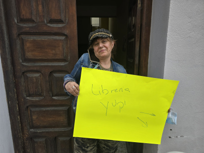 Tonia Escudero anuncia la nueva ubicación de su librería y kiosko con una cartulina amarilla