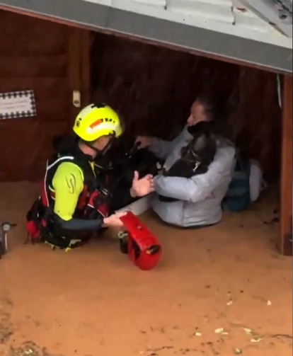 Captura de video cedido este martes por el Aeropuerto de Valencia que muestra un integrante de las fuerzas de socorro rescatando a una mujer dentro de una inundación en Valencia (España).