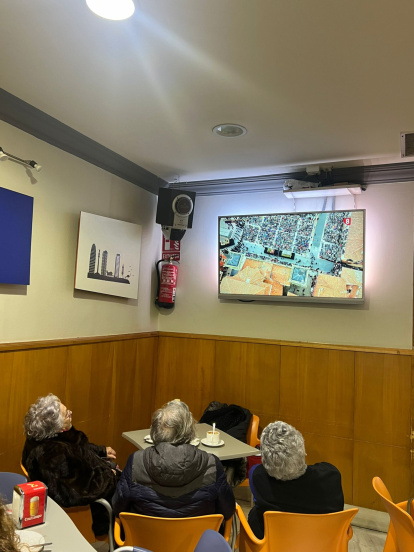 Tres mujeres siguen en directo la procesión de Los Pasos desde el bar Marbella.