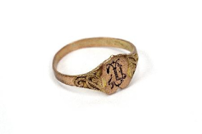 Aro plano que se ensancha en la parte superior formando un escudo, en el que están grabadas dos iniciales (C y T) entrelazadas. En ambos lados, presenta una decoración vegetal estilizada. Pertenece al tipo de `anillos de sello`. Obra entregada en calidad de depósito por el Ministerio de Cultura al Museo del Pueblo Español, el 23 de septiembre de 1978 (en copia mecanografiada se transcribe erróneamente 1971). La obra se encontraba en el Casón del Buen Retiro, sede de los almacenes de la Comisaría del Patrimonio Artístico desde 1971.