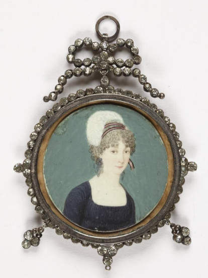 Miniatura circular con retrato femenino de busto. La figura, recortada sobre un fondo azul-verdoso, está levemente girada hacia su izquierda, pero mirando hacia el frente. La dama va ataviada con un vestido azul oscuro de manga larga, escote cuadrado y fruncido en el pecho, de talle alto estilo Imperio. Luce unos grandes pendientes de brillantes como única joya. Edad Contemporánea.
Obra entregada en calidad de depósito por la Comisaría General del Patrimonio Artístico Nacional el 18 de junio de 1943.