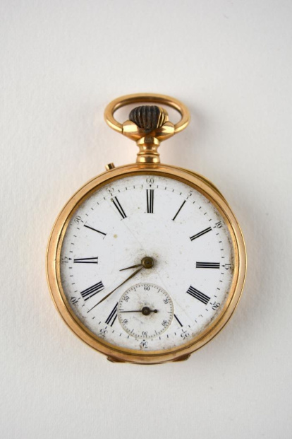 Reloj de bolsillo de tipo lepine en oro, con caja, tapa posterior, guardapolvo y anilla en oro. La esfera es de porcelana con las horarias en números romanos y arábigos, esmaltados en negro. Dentro de dicha esfera en el extremo inferior está el segundero en números arábigos. Las tres manecillas tienen forma lanceolada. Carece de cristal. Los relojes de bolsillo han sido tradicionalmente considerados como un símbolo de poder, riqueza y distinción. Tienen su origen en Francia, a mediados del siglo XV. Obra entregada en calidad de depósito por el Ministerio de Cultura al Museo Nacional de Cerámica, el 23 de septiembre de 1978.
