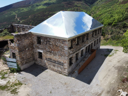 El tejado de aluminio-espejo atrapa las nubes en el antiguo economato del poblado de La Piela, reconvertido en el centro de visitantes La Montaña Negra