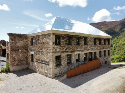 El tejado de aluminio-espejo atrapa las nubes en el antiguo economato del poblado de La Piela, reconvertido en el centro de visitantes La Montaña Negra