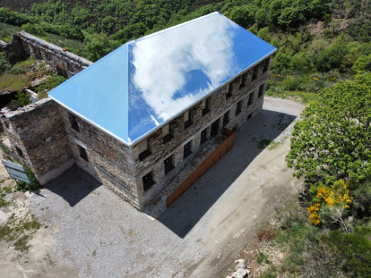 El tejado de aluminio-espejo atrapa las nubes en el antiguo economato del poblado de La Piela, reconvertido en el centro de visitantes La Montaña Negra