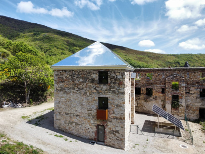 El tejado de aluminio-espejo atrapa las nubes en el antiguo economato del poblado de La Piela, reconvertido en el centro de visitantes La Montaña Negra