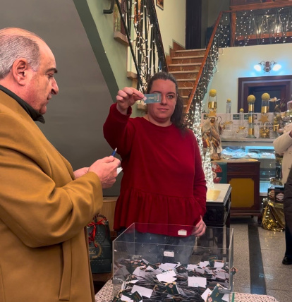 La afortunada sostiene la papeleta ganadora del roscón de Confiterías Conrado en La Bañeza.