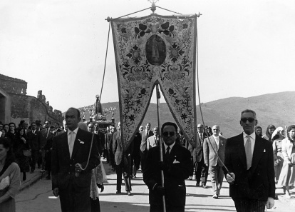 Ricardo Gavilanes Cubero porta el pendón de la Virgen acompañado, a su derecha, por Ángel Arias Barredo y a su izquierda, por Don Alejandro Hernández Martín.