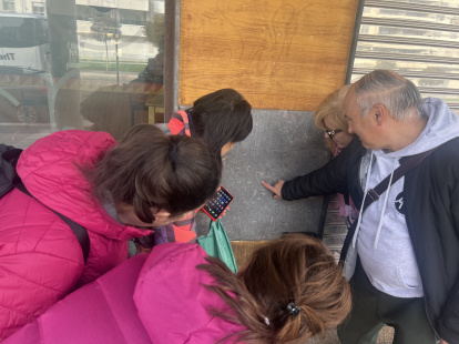 Vecinas del edificio de la calle La Alameda observan otro fósil urbano, este del Jurásico, en la fachada de la cafetería Recolás.