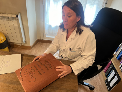 Marta Fernández de Vega Chávarri con los documentos que conserva de su padre, también farmacéutico, que fue custodio regidor del Cristo de la Victoria. Su farmacia linda con la capilla.