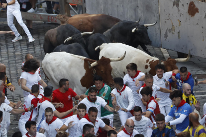 <p>PAMPLONA, 14/07/2026.- Los mozos perseguidos por los toros de la ganadería de Jandilla en el tramo de Mercaderes con Estafeta, en el último encierro de las fiestas de San Fermín de 2026 este martes. EFE/Jesús Diges</p>
